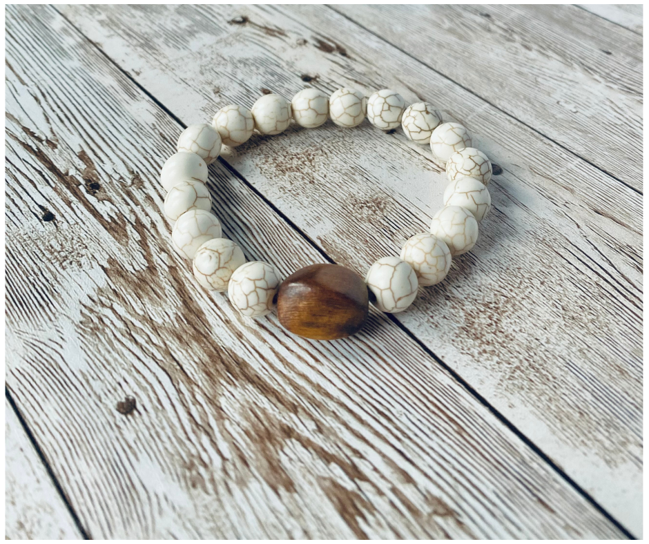 Stretch bracelet with white beads and a larger wood accent bead.